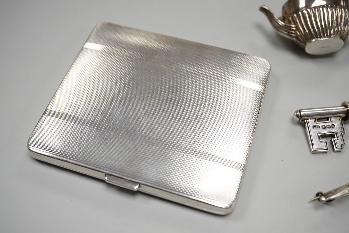 A George V silver presentation key, Vaughton & Sons, Birmingham, 1910, 10.2cm, together with a silver cigarette case, a silver and mother of pearl fruit knife, a miniature 925 demi-fluted teapot and a Scottish hardstone